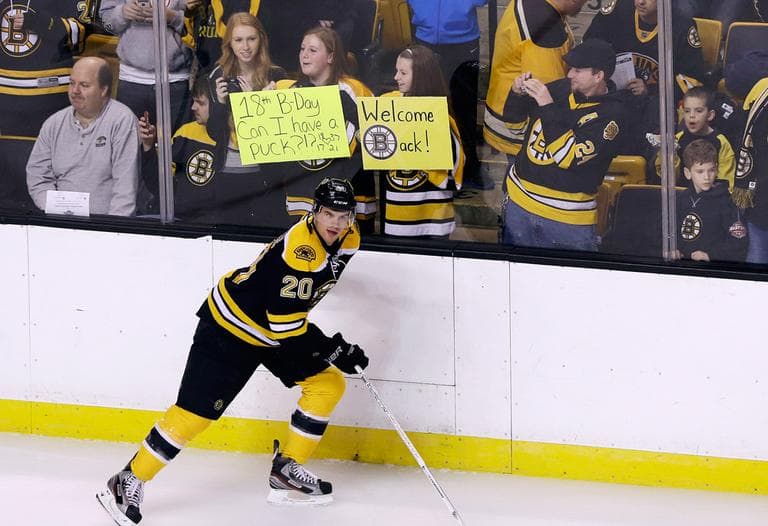 The Bruins' Daniel Paille skates past fans holding signs at Boston's TD Garden before a scrimmage on Tuesday. (Elise Amendola/AP)