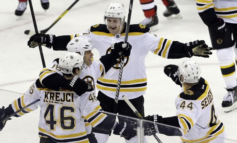 Bruins' David Krejci (46) is congratulated by Nathan Horton, Dennis Seidenberg (44), of Germany, and Dougie Hamilton (27) after Krejci scored the game winning goal against the Carolina Hurricanes. (AP/Gerry Broome)