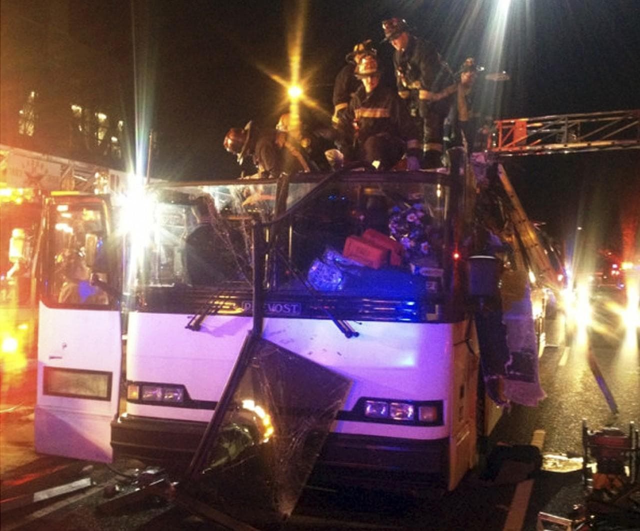 In this photo released by the Boston Fire Department via Twitter, firemen work to remove injured passengers from a bus that hit an bridge as it traveled along Soldiers Field Road in the Allston neighborhood of Boston Saturday night, Feb. 2, 2013. . (Boston Fire Department/AP)