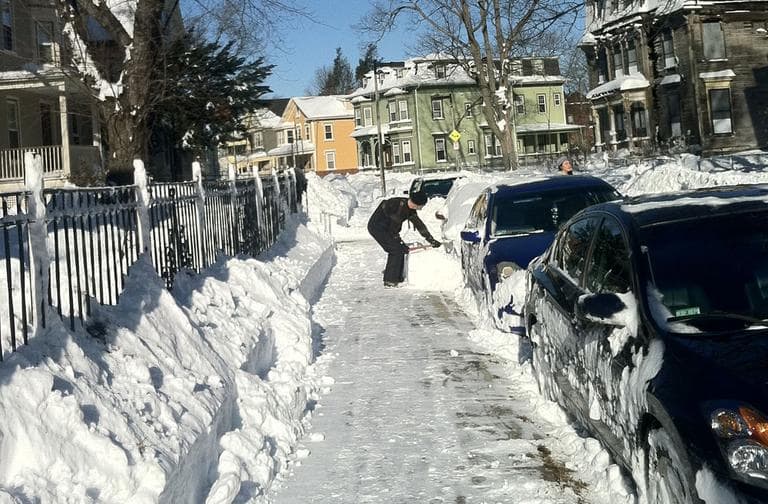 A man shovels out his car on Moreland Street in Roxbury. (Delores Handy/WBUR)