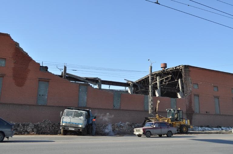 Cars driver psst a zinc factory building with part of its roof collapsed in Chelyabinsk, about 930 miles east of Moscow, Russia, Saturday, Feb. 16, 2013. (Laura Mills/AP)