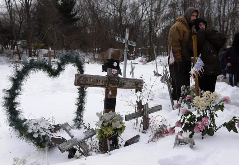 Jason Zubee and his wife, Robin Zubee, stand together near makeshift memorials on the site of The Station nightclub fire on Sunday. Zubee lost her cousin William Christopher Bonardi III in the 2003 blaze at the nightclub that killed 100 people. (Steven Senne/AP)