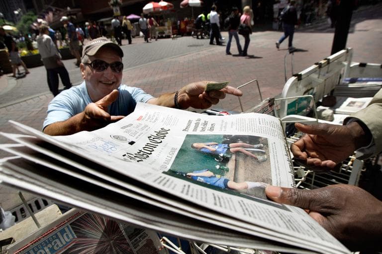 A customer buys a Boston Globe newspaper at a Downtown Crossing newsstand on June 8, 2009. (Elise Amendola/AP)