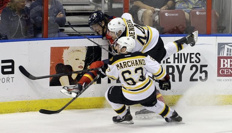 Bruins' Brad Marchand (63) and Dennis Seidenberg (44) battle Florida Panthers' Peter Mueller (88) for the puck. (J Pat Carter/AP)
