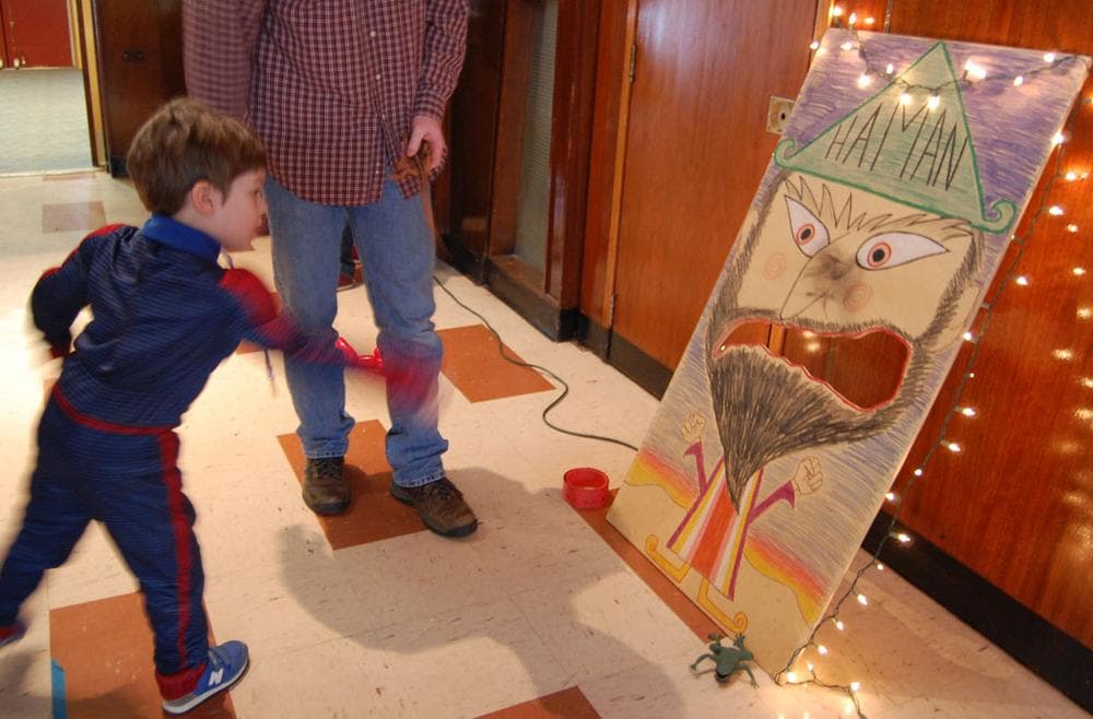 Zachary Dziggel tosses a rubber spider in Haman's mouth. (Greg Cook)