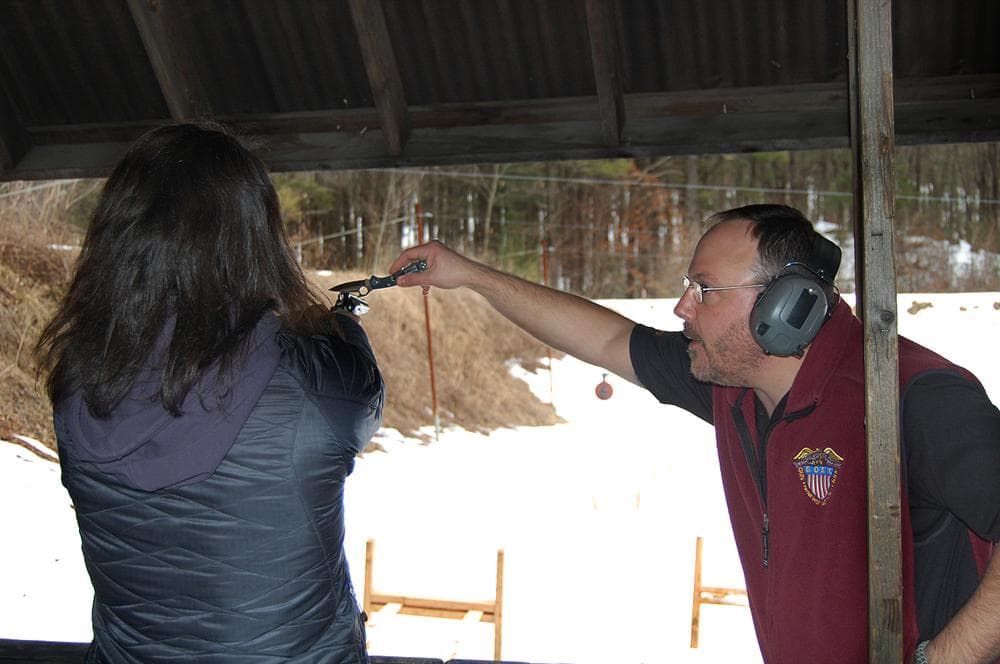 During his course, Green helps a female student make some adjustments in order to increase shooting accuracy. (Kathleen McNerney/WBUR)