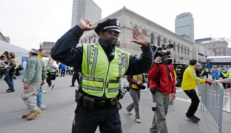 A Boston police officer clears Boylston Street following an explosion at the finish line of the 2013 Boston Marathon in Boston, Monday, April 15, 2013. Two explosions shattered the euphoria at the finish line on Monday, sending authorities out on the course to carry off the injured while the stragglers were rerouted away from the smoking site of the blasts. (Charles Krupa/AP)
