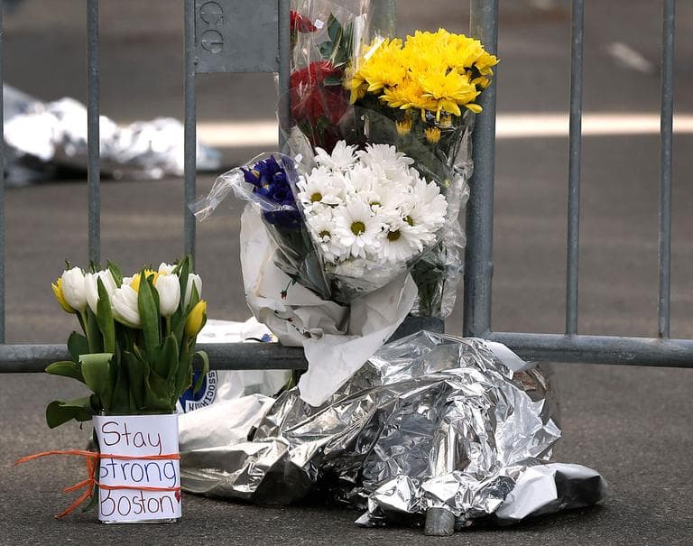 Flowers sit at a police barrier near the finish line of the Boston Marathon in Boston Tuesday, April 16, 2013. (AP Photo/Winslow Townson)