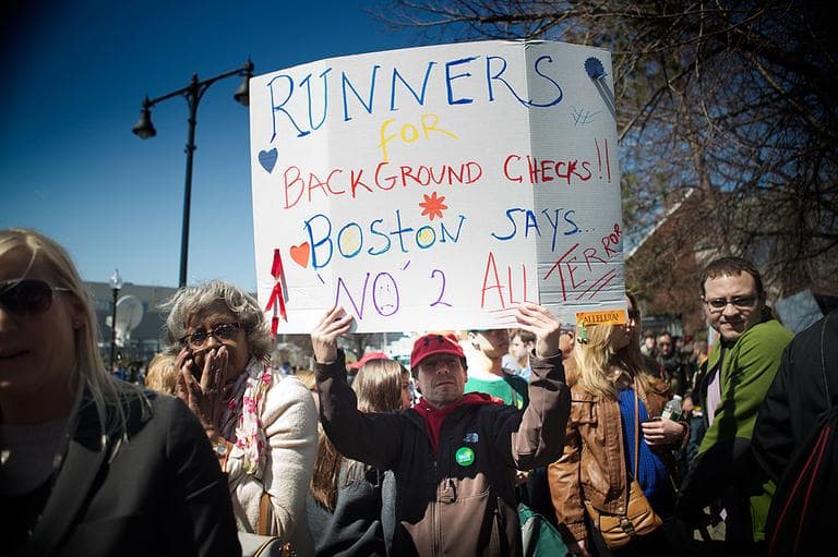 Man holding a sign near the Cathedral of the Holy Cross. (Jesse Costa/WBUR)