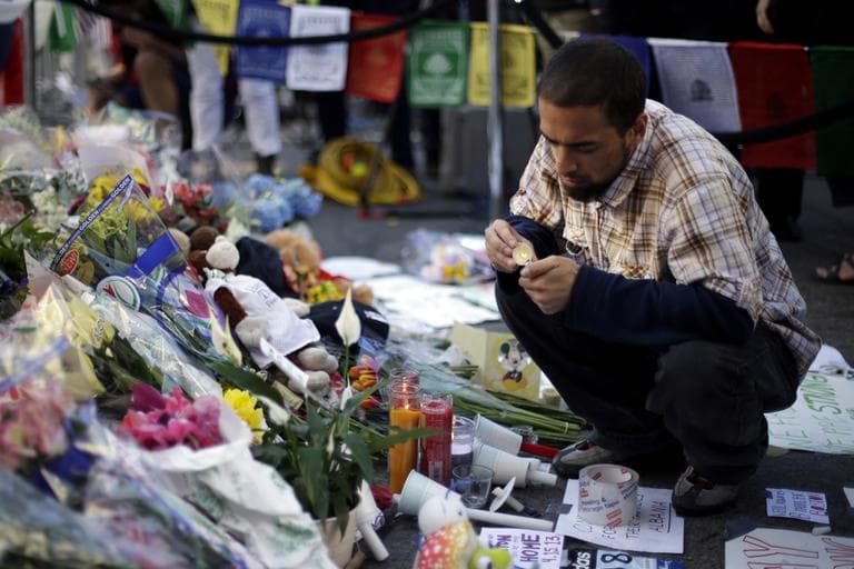 Richard Maldonado lights a candle at a makeshift memorial on Boylston Street near the finish line of the Boston Marathon explosions. (Matt Rourke/AP)