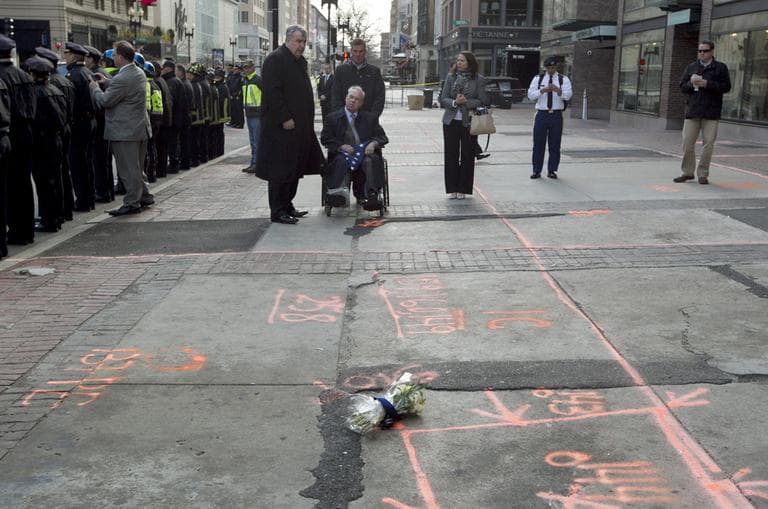 Boston Mayor Thomas Menino, seated, recovering from a broken leg, pauses with Boston Police Commissioner Edward Davis at the blast site on Boylston Street between Dartmouth and Exeter Streets near the Boston Marathon finish line Monday, April 22, 2013, in Boston. Federal investigators formally released the finish line bombing crime scene to the city in a brief ceremony at 5 p.m. (Robert F. Bukaty/AP)