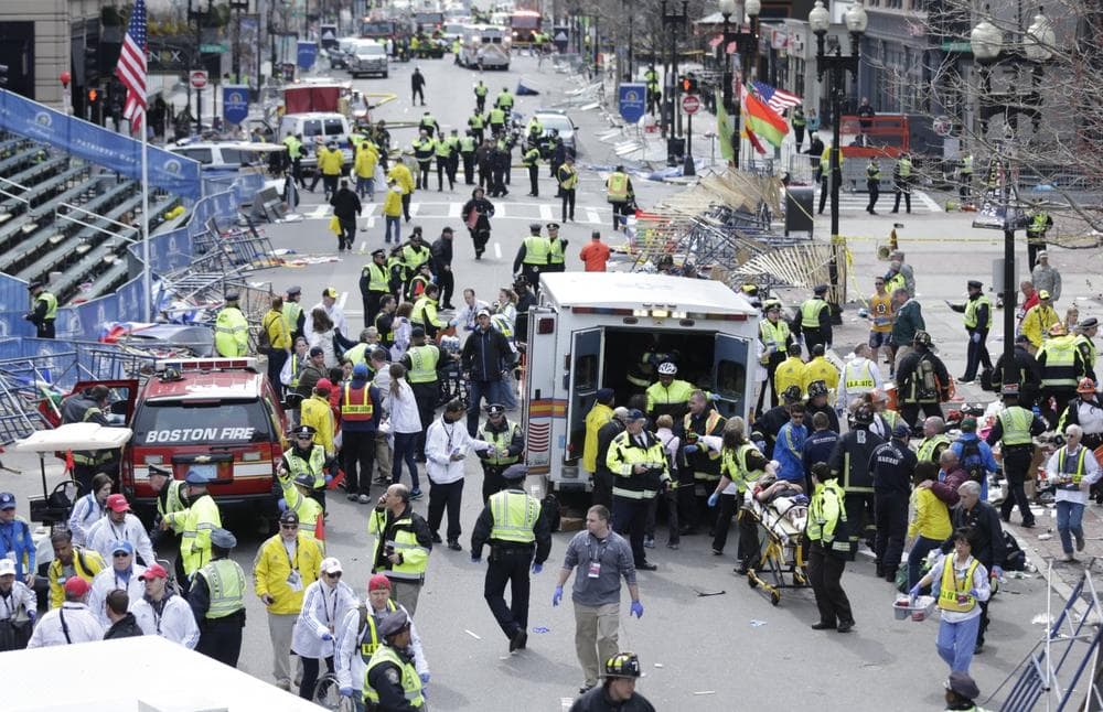 Medical workers aid injured people at the finish line of the 2013 Boston Marathon following an explosion in Boston, Monday, April 15, 2013. (AP Photo/Charles Krupa)