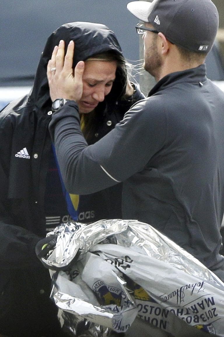 An unidentified Boston Marathon runner is comforted as she cries.(Elise Amendola/AP)