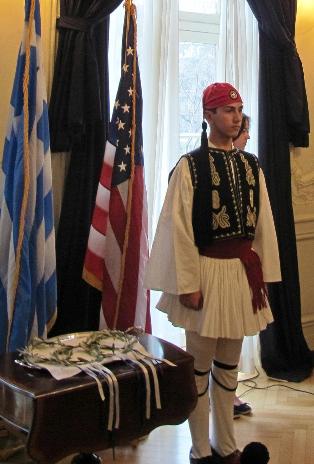 A guard at the Greek consulate protects the Boston Marathon wreaths. (Bill Littlefield/Only A Game)