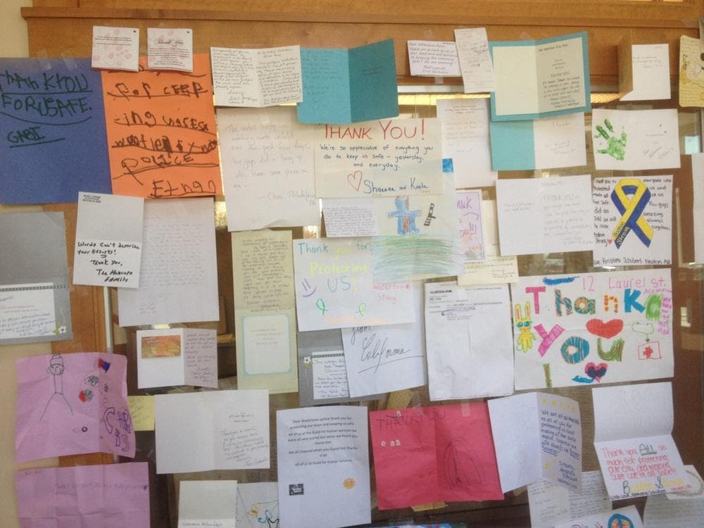 A wall of cards at the Watertown Police Department headquarters. (Martha Bebinger/WBUR)