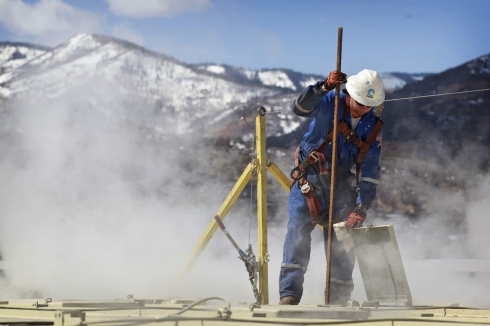 A worker checks a dipstick at an Encana Oil & Gas (USA) Inc. hydraulic fracturing operation at a gas drilling site outside Rifle, Colorado. (AP)