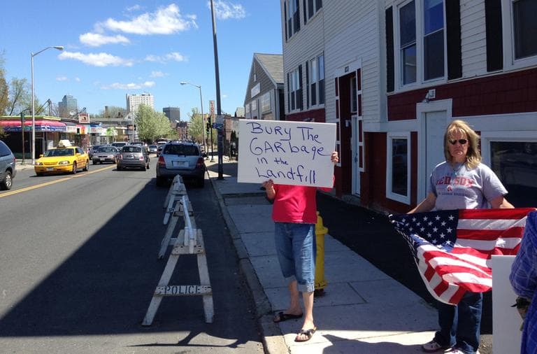 A protester holds a sign with "Bury the garbage in the landfill," referring to the body of suspected Boston Marathon bomber Tamerlan Tsarnaev. (Deborah Becker/WBUR)