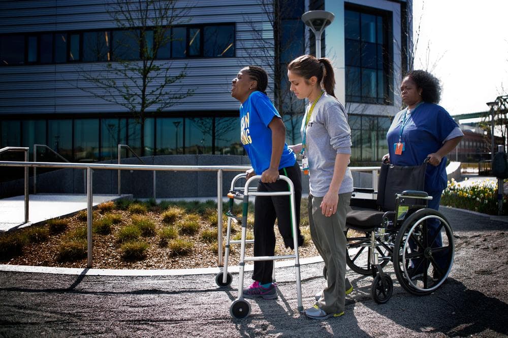 Daniel works with occupational therapist Becky Buttiglieri and Teresa  Ashmead outside of Spaulding. (Jesse Costa/WBUR)