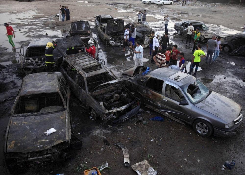 Iraqis gather at the scene of a car bomb attack at a used cars dealers parking lot in Habibiya neighborhood of eastern Baghdad, Iraq, Monday, May 27, 2013. (Karim Kadim/AP)