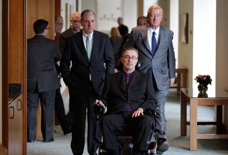 In this 2012 photo, former Gov. William Weld (right) and Michael Collins, Chancellor of the University of Massachusetts Medical School (left), accompany former Gov. Paul Cellucci (center) into a news conference where Biogen announced a donation to ALS research in Boston. (Stephan Savoia/AP)