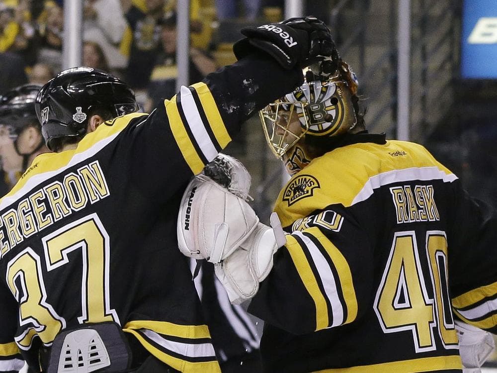 Boston Bruins Patrice Bergeron congratulates Boston Bruins goalie Tuukka Rask on his shutout to beat the Chicago Blackhawks on Monday. (AP/Elise Amendola)