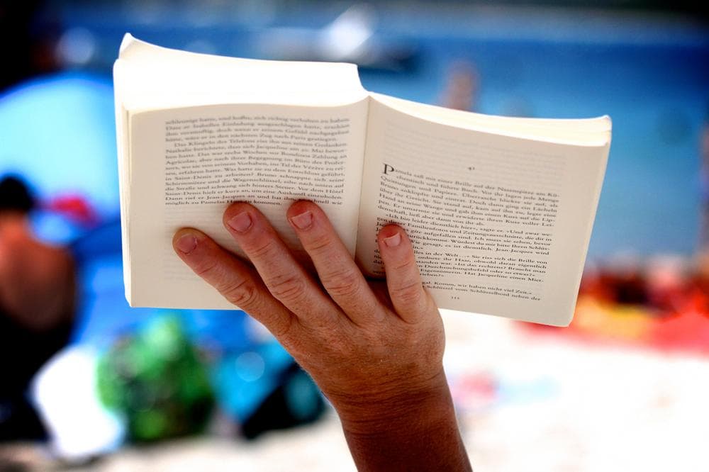 Reading a book at the beach. (.christoph.G./Flickr)