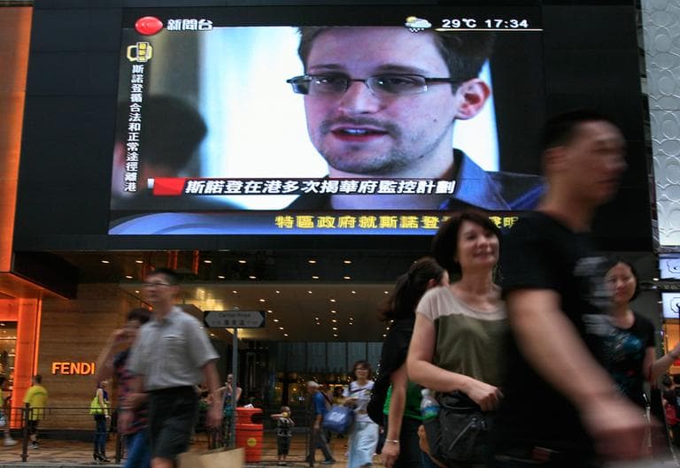 A TV screen shows a news report of Edward Snowden, a former CIA employee who leaked top-secret documents about sweeping U.S. surveillance programs, at a shopping mall in Hong Kong Sunday, June 23, 2013. The former National Security Agency contractor wanted by the United States for revealing two highly classified surveillance programs has been allowed to leave for a "third country" because a U.S. extradition request did not fully comply with Hong Kong law, the territory's government said Sunday. (Vincent Yu/AP)