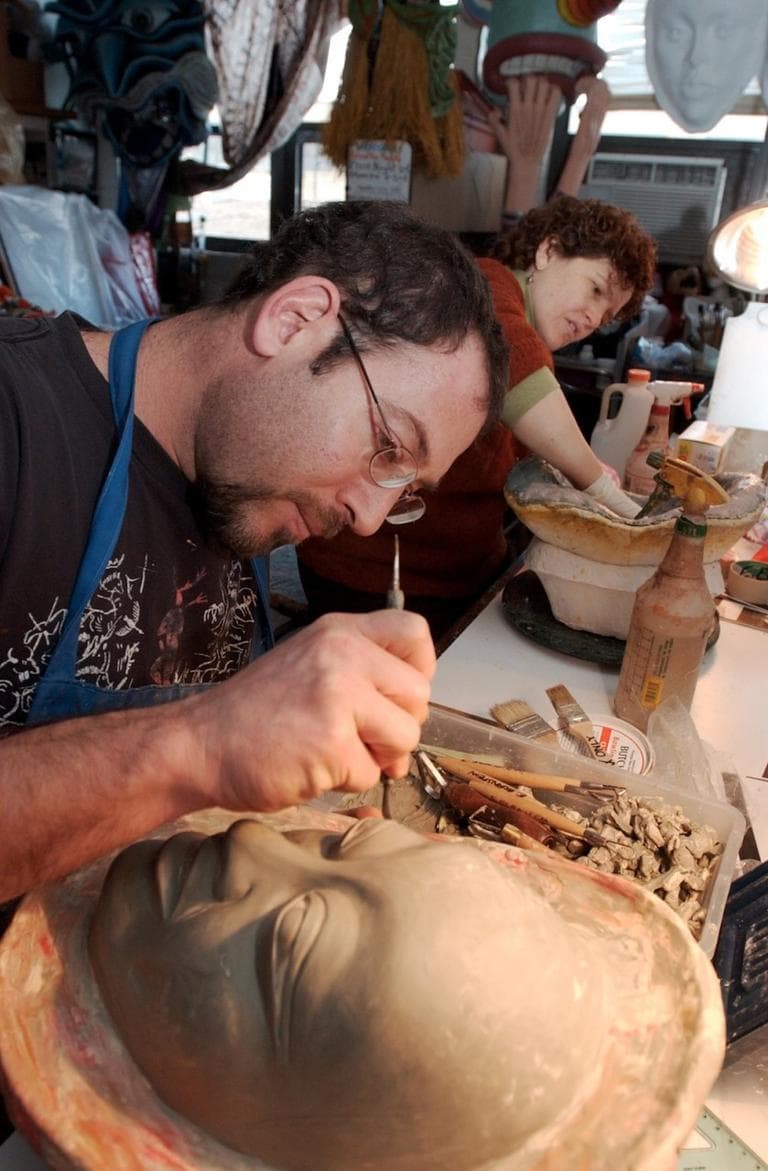 Eric Bornstein smooths the surface of a clay mask mold before applying plaster. before 2002 First Night. (SEVANS/AP)