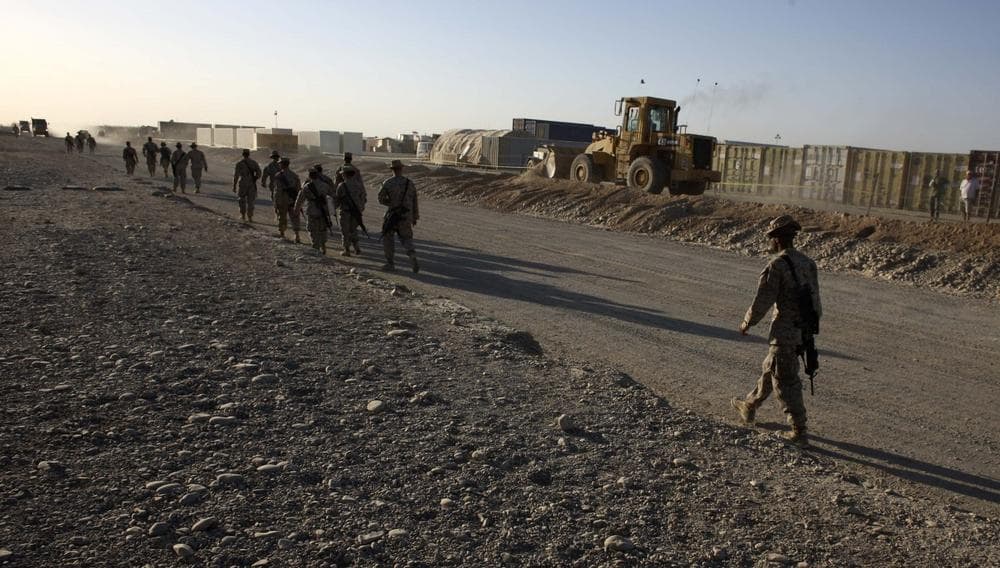 U.S. Marines walk past heavy machinery and containers where construction is taking place inside Camp Leatherneck, in Helmand province, southern Afghanistan, Oct. 9, 2009. (Brennan Linsley/AP)