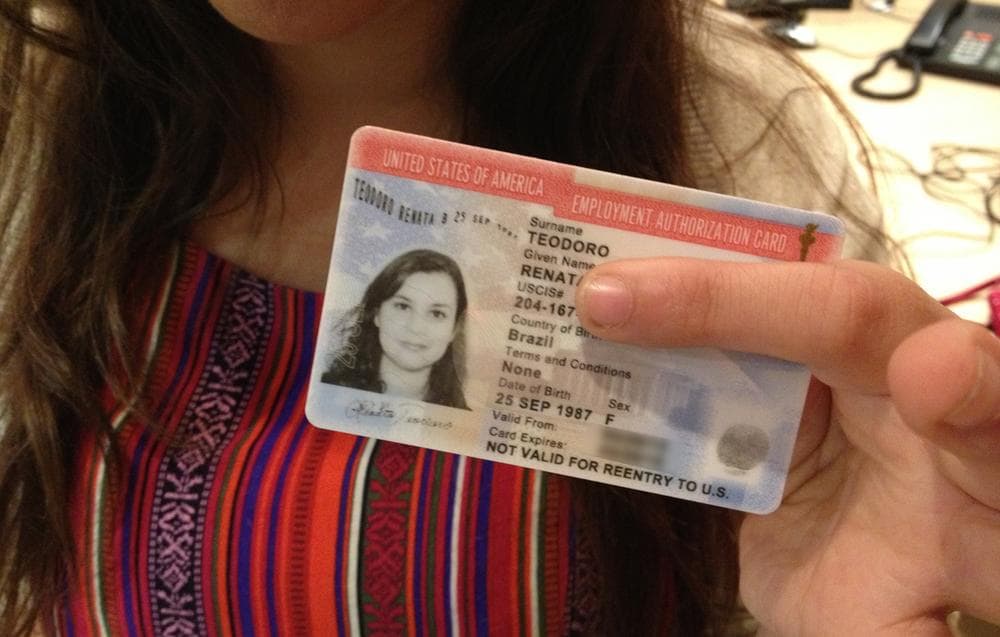 Renata Teodoro holds up her U.S. employment authorization card. (Here & Now)