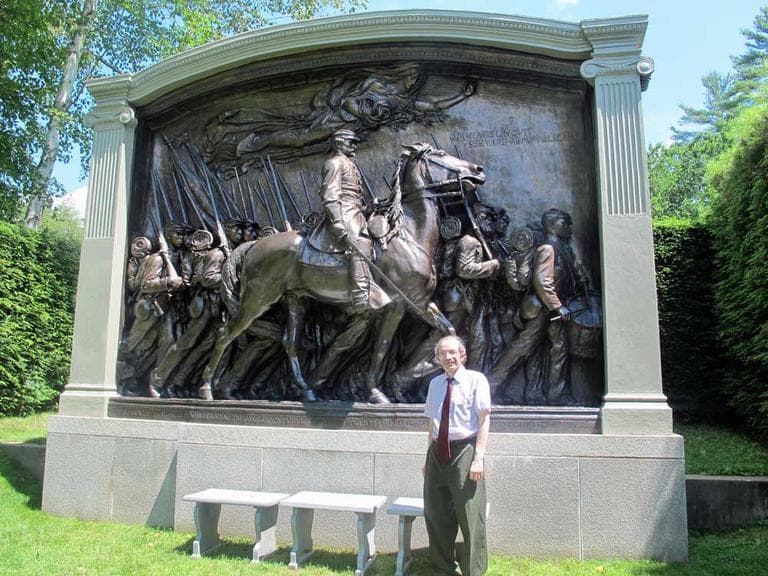 Curator Henry Duffy standing in front Augustus Saint-Gaudens' final version of the Shaw memorial on the grounds of the artist's former home in Cornish, N.H. (Andrea Shea/WBUR)