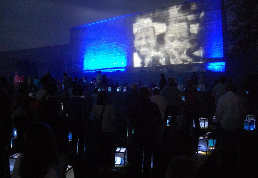 Lanterns glow among the audience watching King's speech projected onto Fort Independence. (Greg Cook)