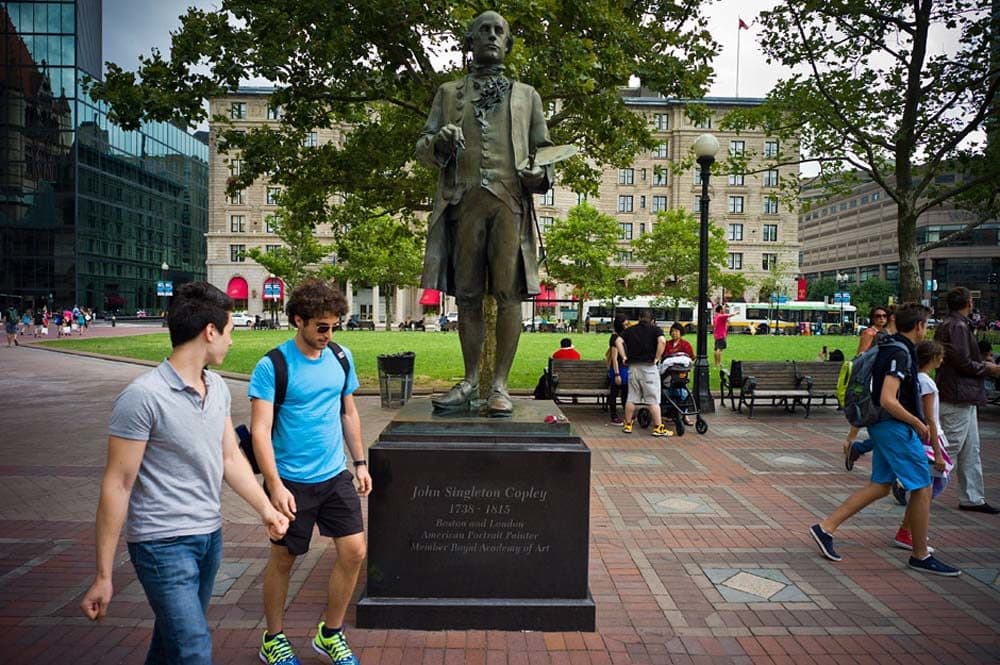 Pedestrians pass by a statue of John Singleton Copley, the portraitist and namesake for the square, in this 2013 file photo. (Dominick Reuter for WBUR)
