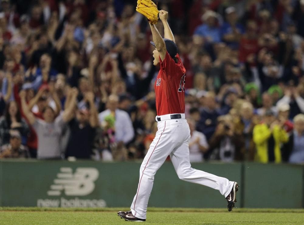 Red Sox relief pitcher Koji Uehara raises his arms as he celebrates the final out after the Red Sox clinched the AL East title.(AP)