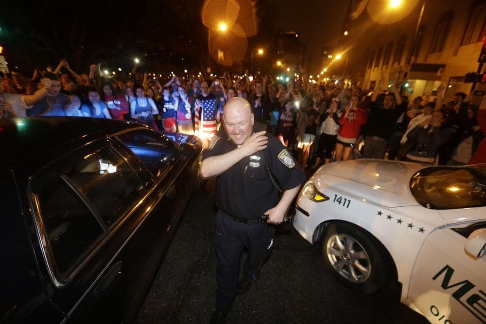 A police officer reacts to news of the arrest of one of the Boston Marathon bombing suspects. (Julio Cortez/AP)