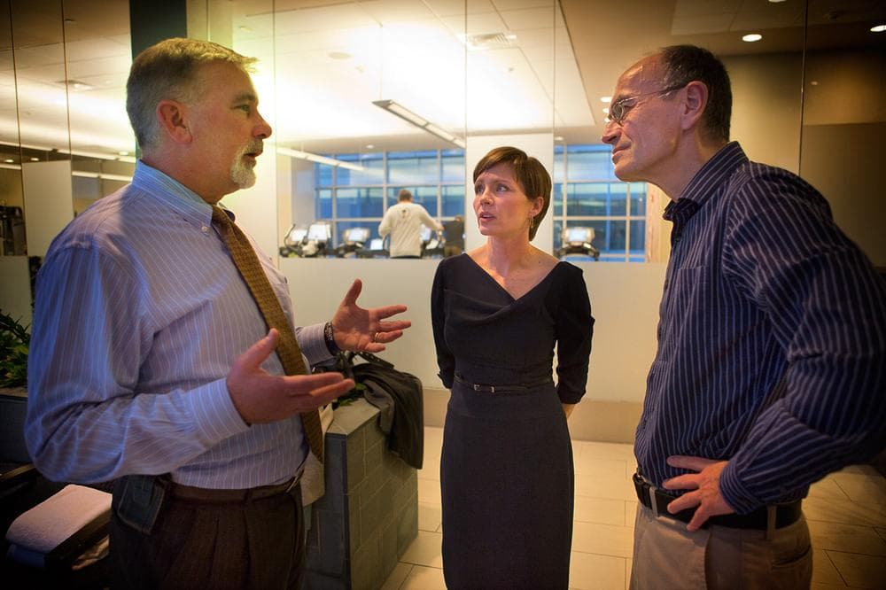 Chris Supple, left, and his wife Kate, center, speak with Thomas Sudhof, right, whose been studying their son's genes for years. (Jesse Costa/WBUR)