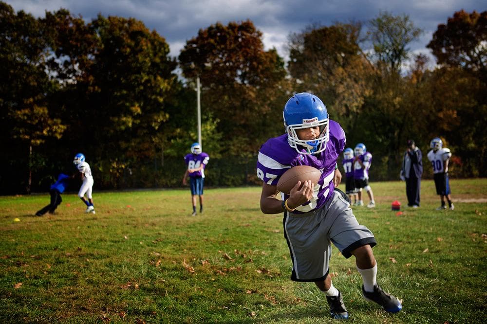 The Mildred Avenue Middle School football team practices afterschool at the George H. Walker Playground on Norfolk Street. (Jesse Costa/WBUR)