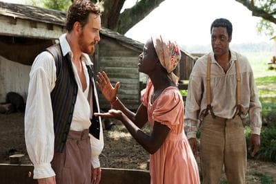 Plantation owner Edwin Epps (Michael Fassbender) addresses his slave, Patsey (Lupita Nyong'o) as Solomon Northrup (Chiwetel Ejiofor) looks on in the 2013 film, "12 Years A Slave." (Fox Searchlight Pictures)