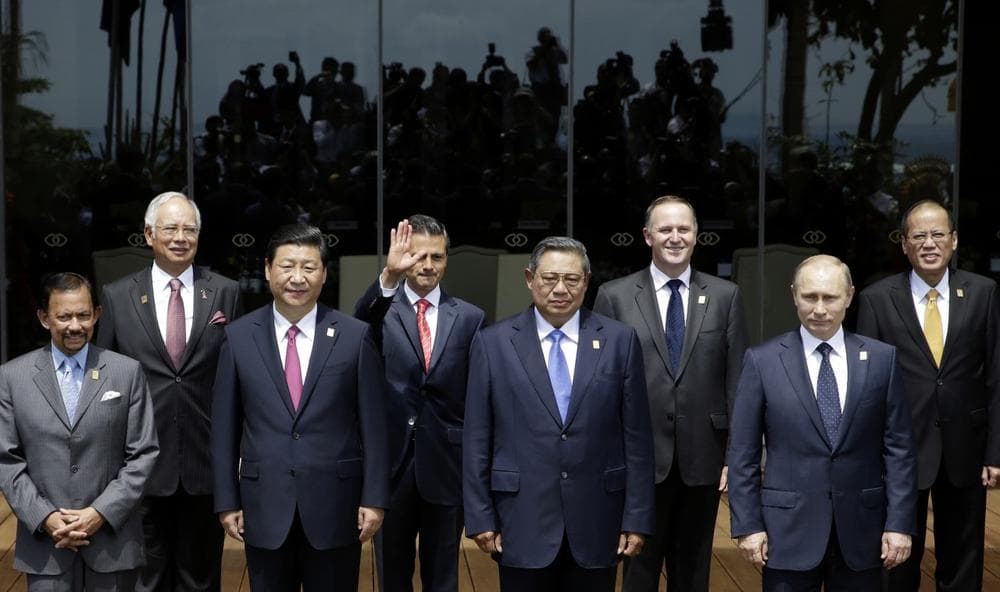 Photographers are reflected on the glass, background, as leaders of the Asia-Pacific region stand for a group photo session during the Asia-Pacific Economic Cooperation (APEC) forum in Bali, Indonesia, Tuesday, Oct. 8, 2013 (AP)