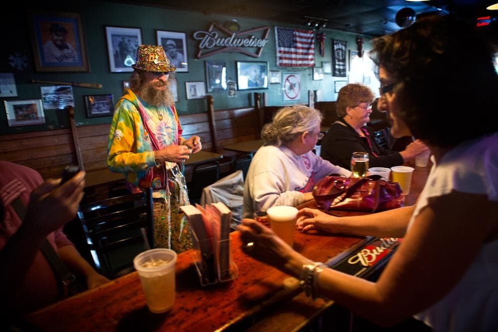Jennie Cherry serves Andrew Norris, center, a regular at Eddie C's. (Jesse Costa/WBUR)
