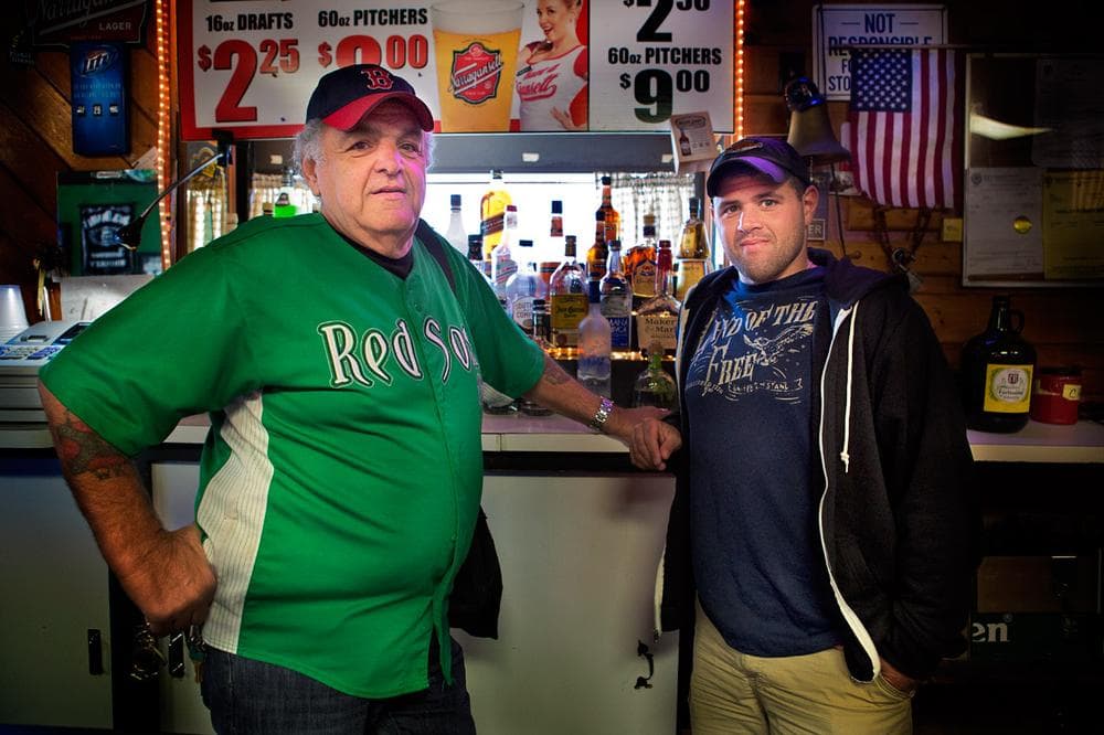 Eddie Contilli, left, and his son, Michael, who will eventually take over the family business, behind the bar at Eddie C’s. (Jesse Costa/WBUR)