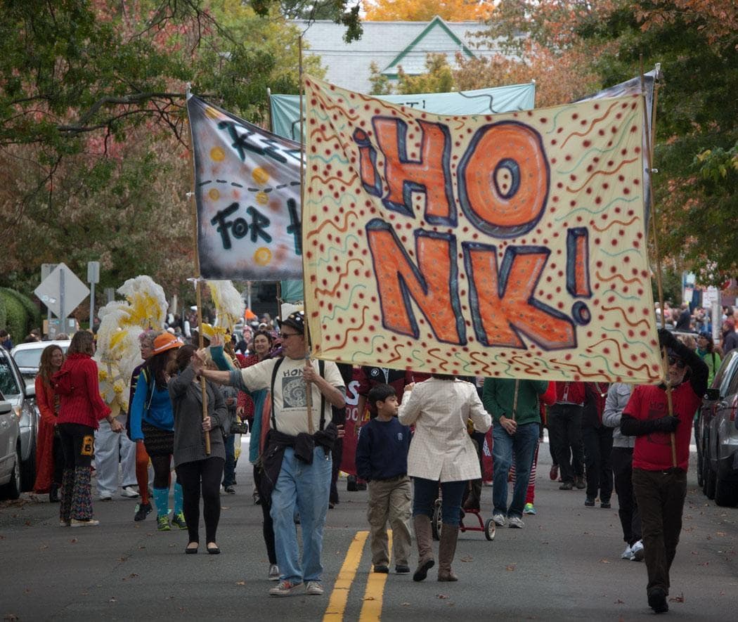 Banners calling for people to “Reclaim the streets for horns, bikes, and feet” lead the 2013 Honk parade. (Greg Cook/WBUR)