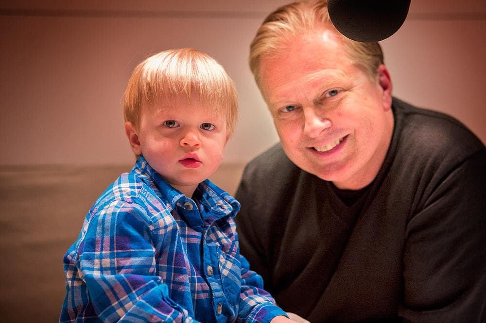 Intrepid young On Point fan Nolan Tosh seems unimpressed by his surroundings in the On Point studio with host Tom Ashbrook. (WBUR)