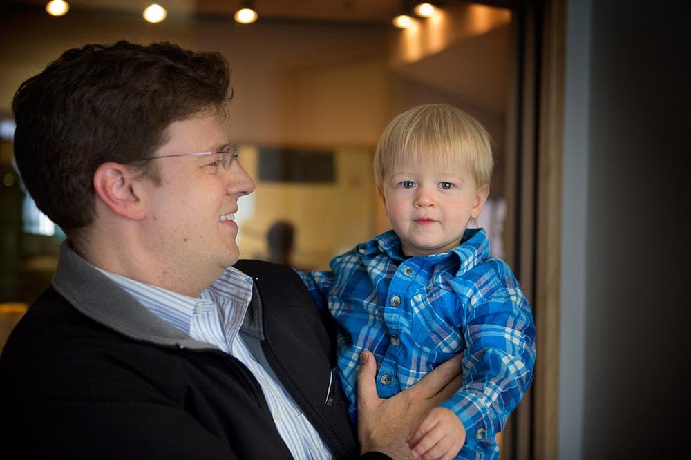 Ian Tosh holds up intrepid young fan Nolan, his son. Nolan dressed on On Point host Tom Ashbrook for Halloween this year. (WBUR)