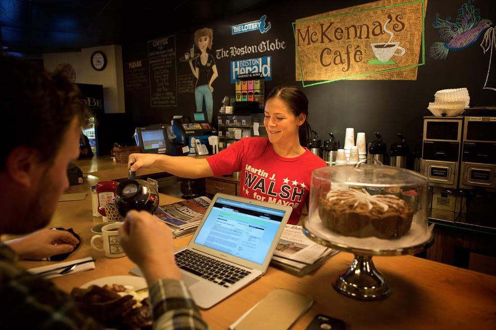 – Bridget McDonagh shows her support for Walsh while serving a patron at McKenna’s Café on Savin Hill Avenue. (Jesse Costa/WBUR)