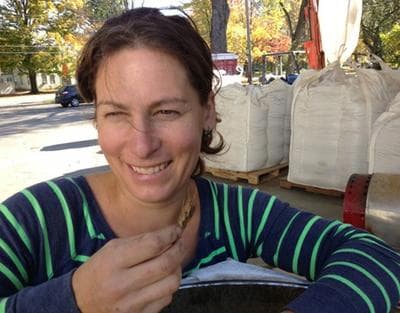 Andrea Stanley holds up grain she's malting for beer at her malt house in Hadley. (Nancy Eve Cohen for WBUR)