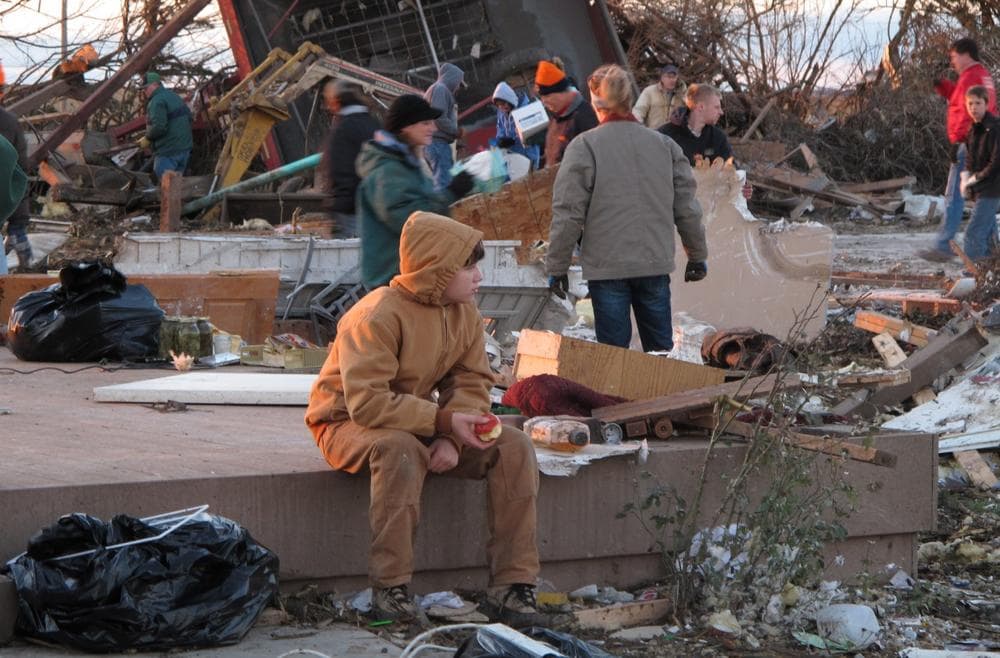 A young boy takes a break from helping comb the rubble of Curt Zehr's home just outside Washington, Ill., on Sunday, Nov. 17, 2013. (David Mercer/AP)