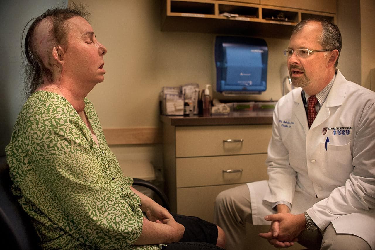 Dr. Pomahac speaks with Carmen Tarleton, who in February received a full face transplant, during a July examination. (Jesse Costa/WBUR)