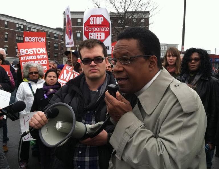 Outside a Burger King in Boston's Dorchester, the Rev. Mark Scott speaks in support of a higher minimum wage. (Jack Lepiarz/WBUR)
