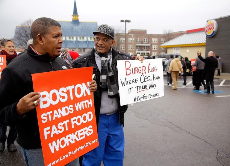 Pedro Rodriguez, right, talks with Andrus Reyes at a Burger King in Boston's Dorchester on Thursday, as part of nationwide protests in support of higher wages for workers in the fast-food industry and other minimum-wage job. (Stephan Savoia/AP)